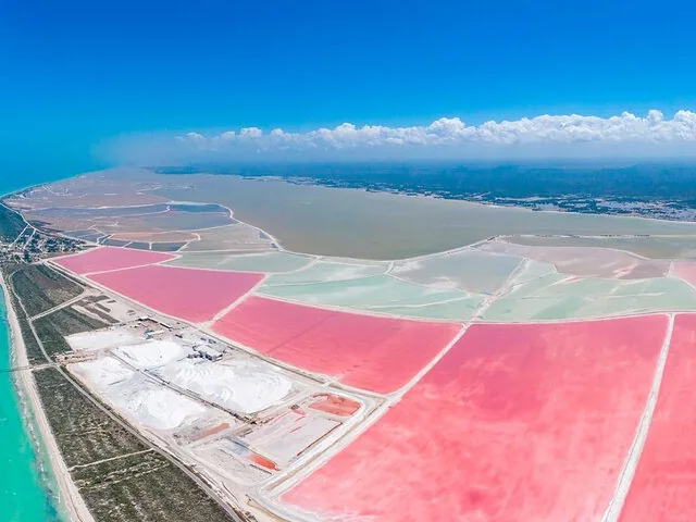 Luftaufnahme farbenfroher Salzverdunstungsbecken mit leuchtend rosa Bereichen.