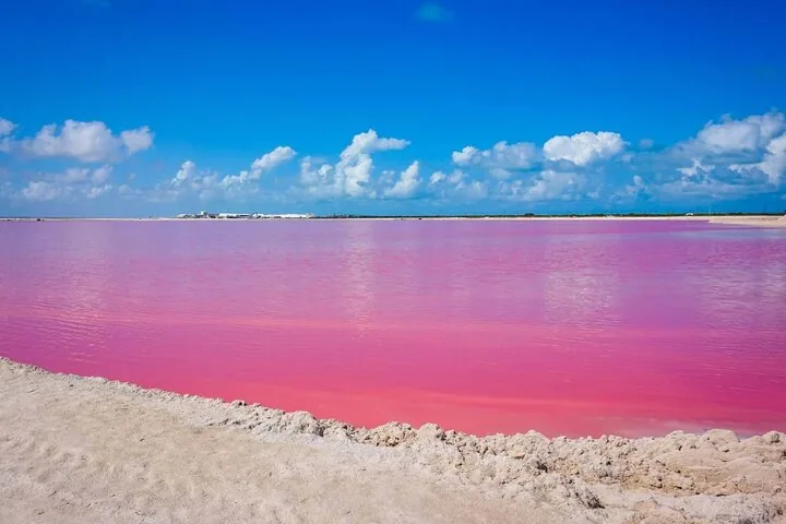 Een rustgevend uitzicht op een levendig roze meer onder een blauwe lucht.