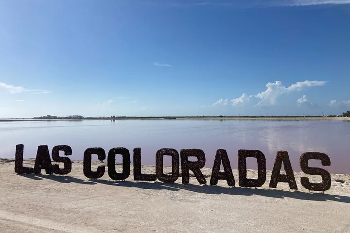 Ein großes Schild mit der Aufschrift „LAS COLORADAS“ an einer rosa Lagune.